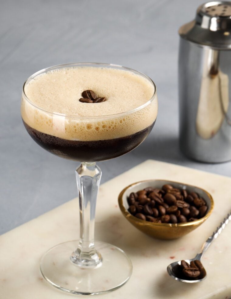 espresso martini garnished with coffee beans with cocktail shaker