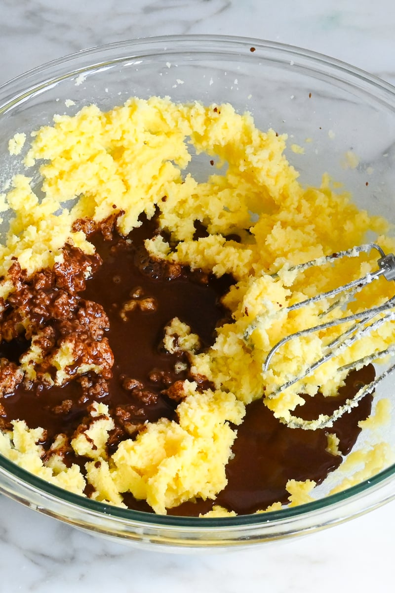 chocolate added to creamed butter, sugar, and egg mixture in mixing bowl.