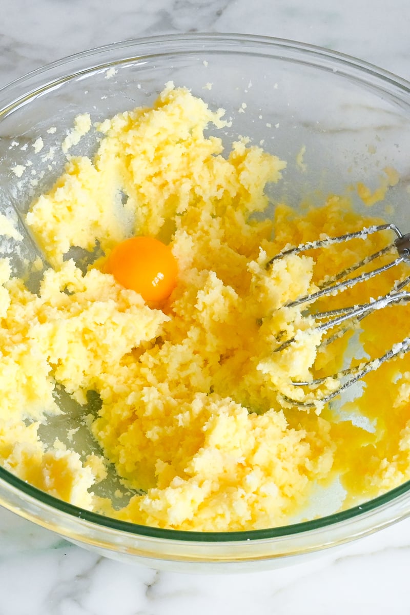 egg yolk added to creamed butter and sugar in bowl.