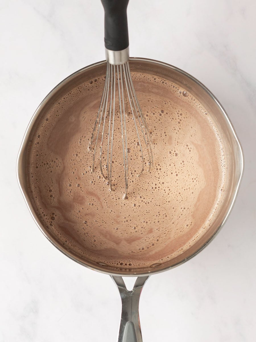 hot chocolate in saucepan with whisk.