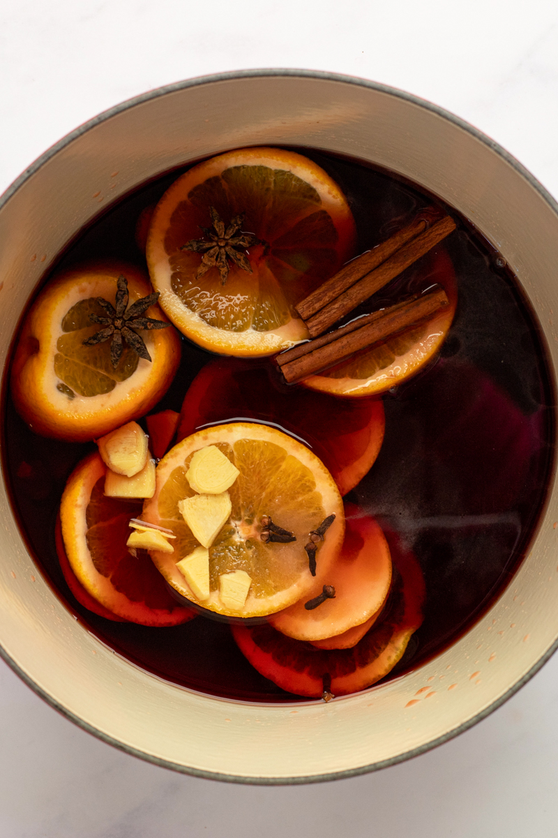 Wine, orange slices, brandy, honey, sugar, cinnamon, cloves, star anise, and ginger in a large saucepan.