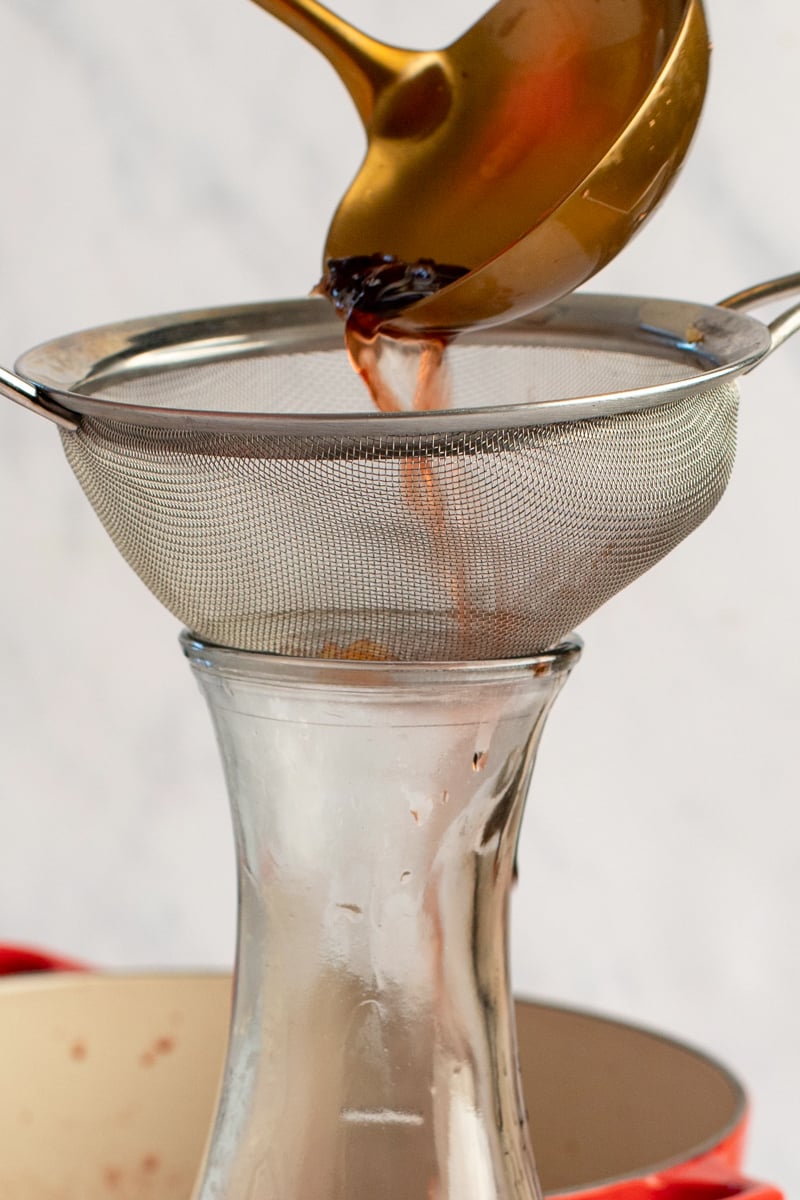 Straining the solids from the mulled wine