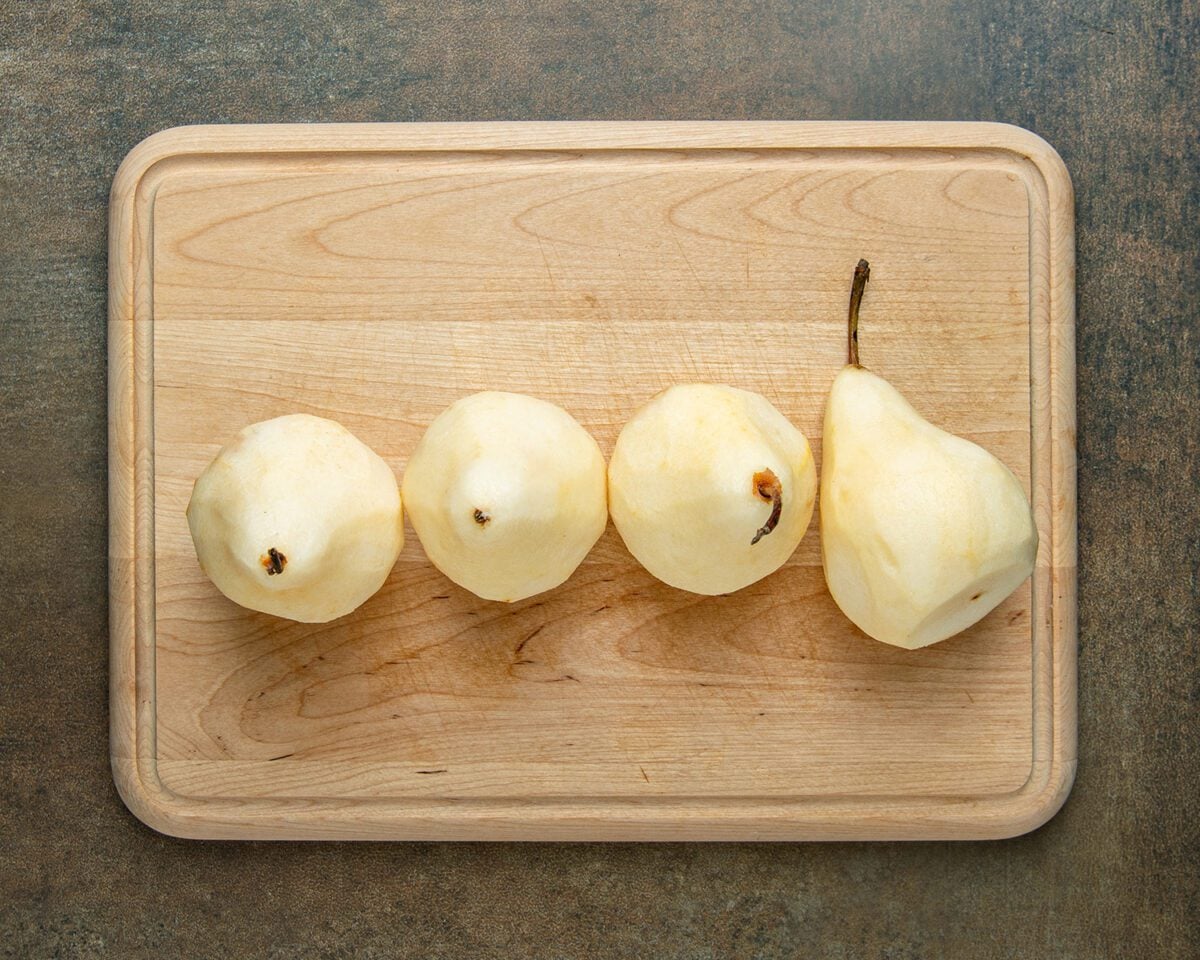 peeled pears on wood cutting board
