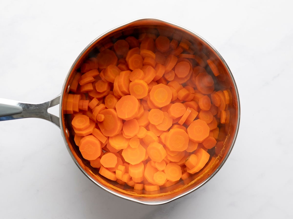 cooked sliced carrots in large saucepan