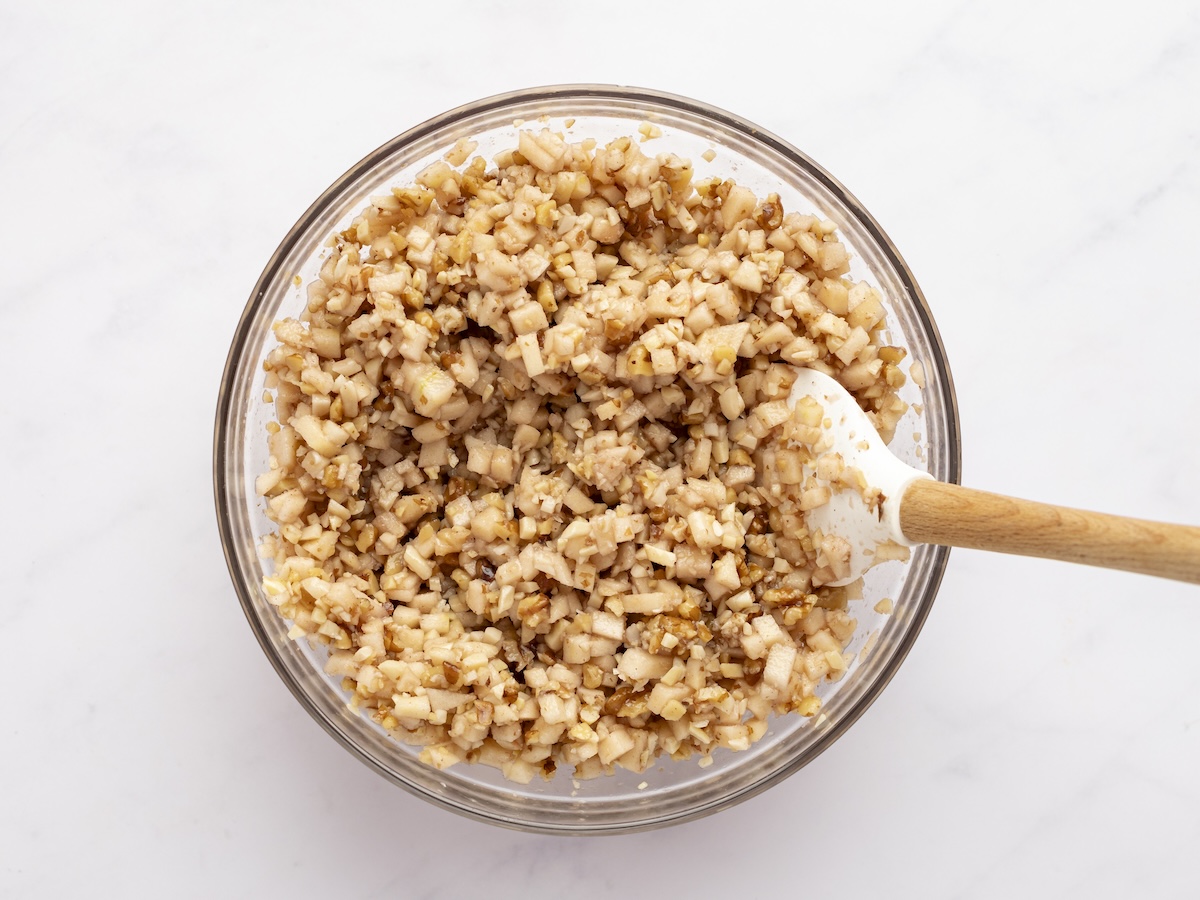 medium bowl with spatula mixing all charoset ingredients together