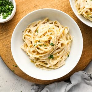 fettuccine alfredo in white bowl with gray napkin to the lower right