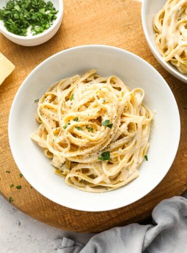 fettuccine alfredo in white bowl with gray napkin to the lower right