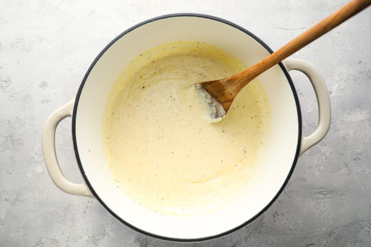 Dutch oven with cheese added to butter/cream sauce