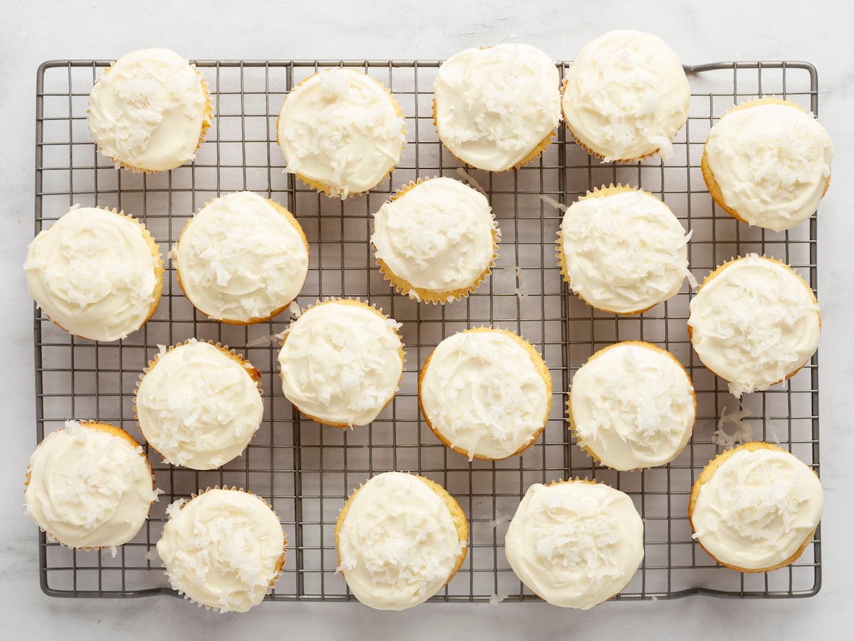 cupcakes on cooling rack with frosting and coconut topping