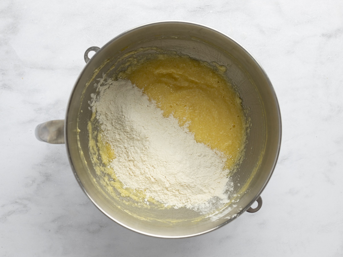 coconut cupcake batter in mixing bowl with dry ingredients and coconut milk mixture being added