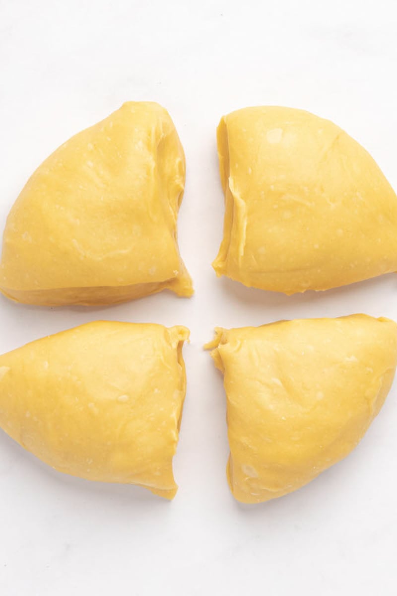 pasta dough divided into four pieces.