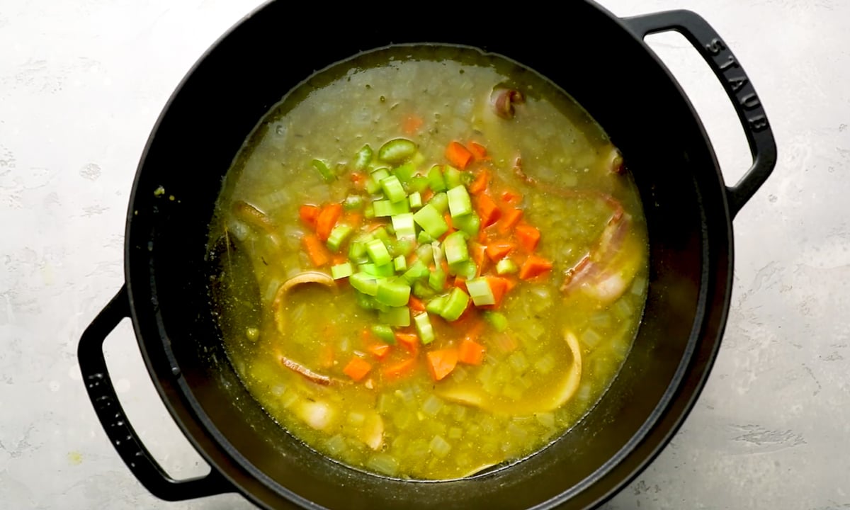 Carrots and celery added to pot of simmering split pea soup.