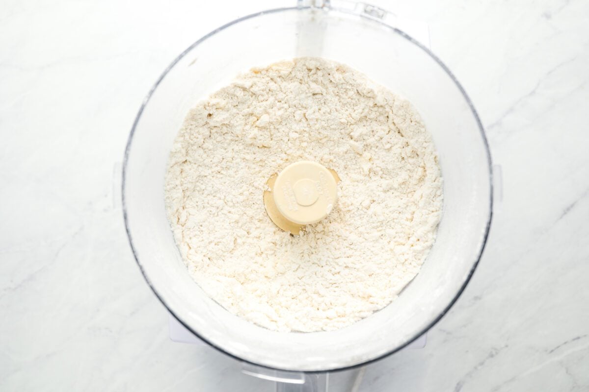 butter combined with flour, cornstarch, baking powder, baking soda, sugar and salt in bowl of food processor