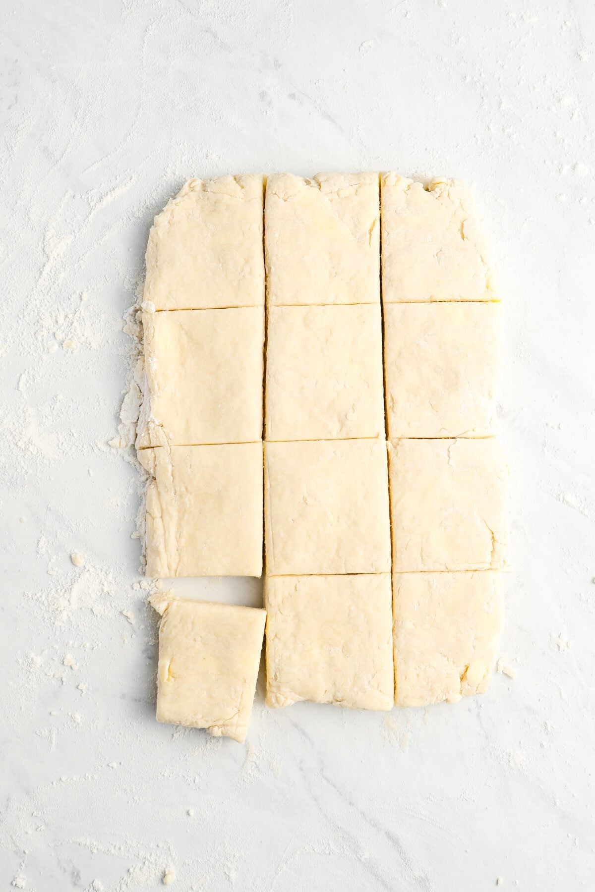 rectangle of buttermilk biscuit dough sliced into 12 even squares