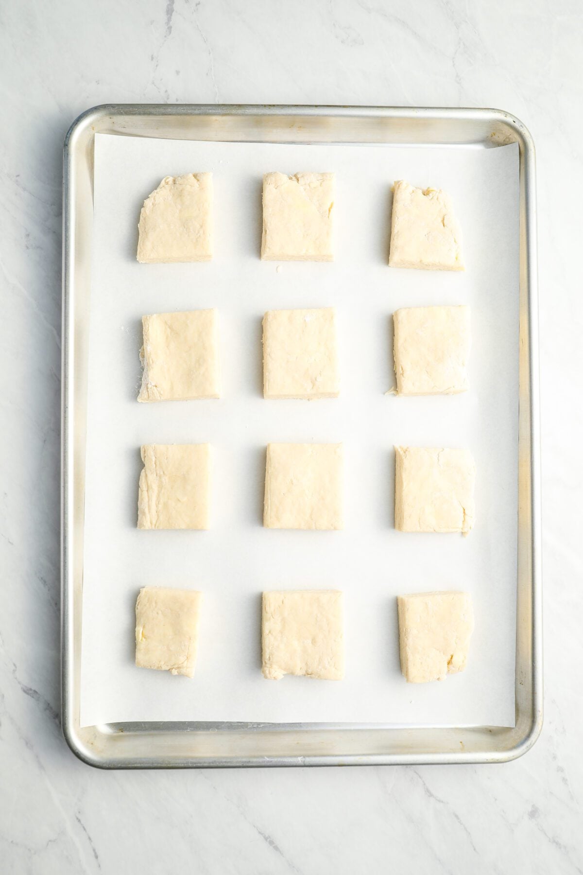 dough squares evenly spaced on parchment-lined baking sheet