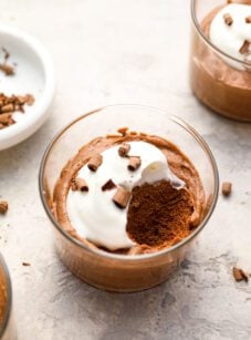 small glass with chocolate mousse topped with whipped cream and chocolate shavings