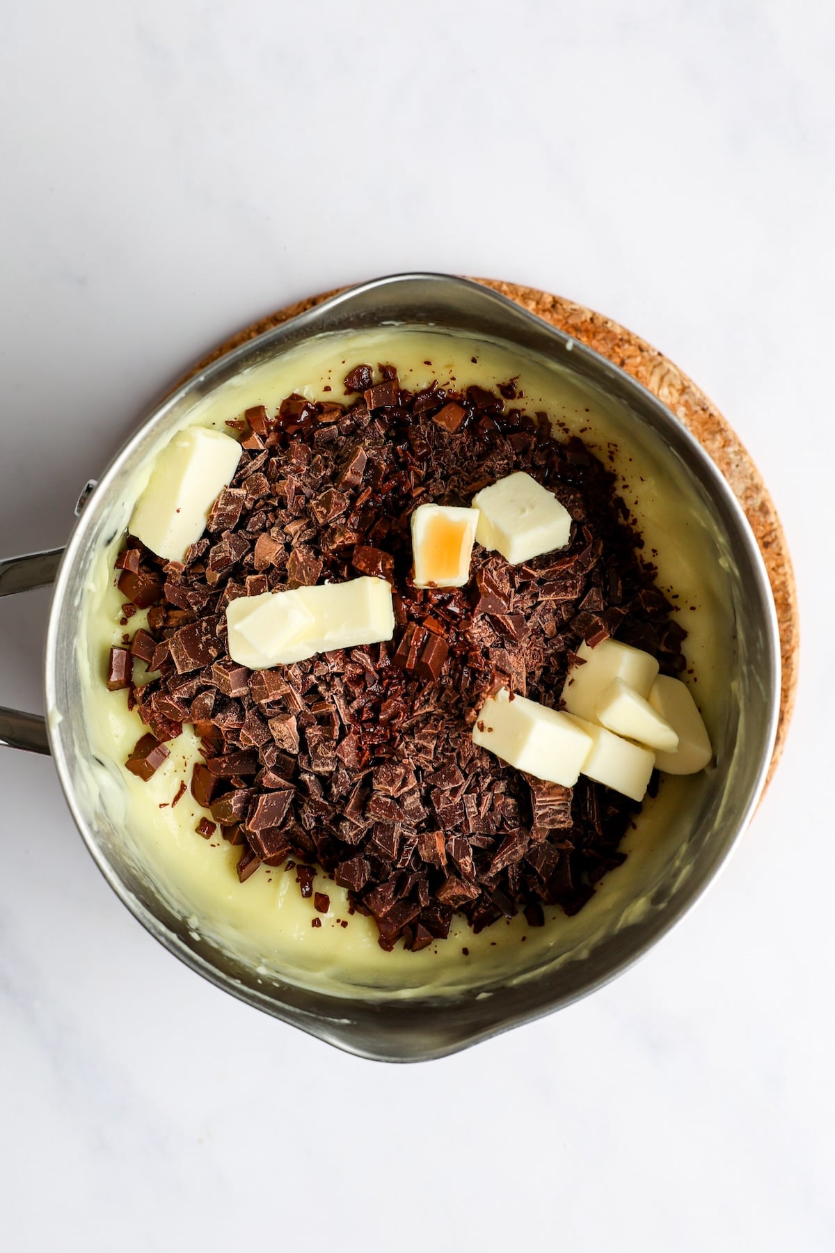 adding butter and chocolate to pastry cream base