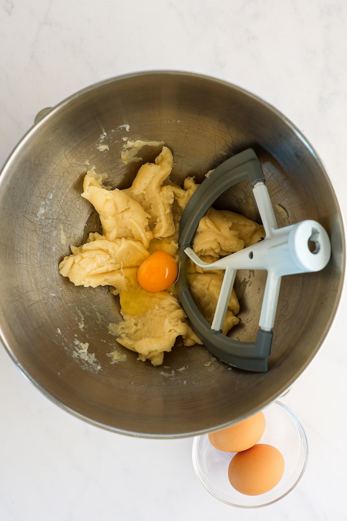 mixing bowl with dough, vanilla, and egg