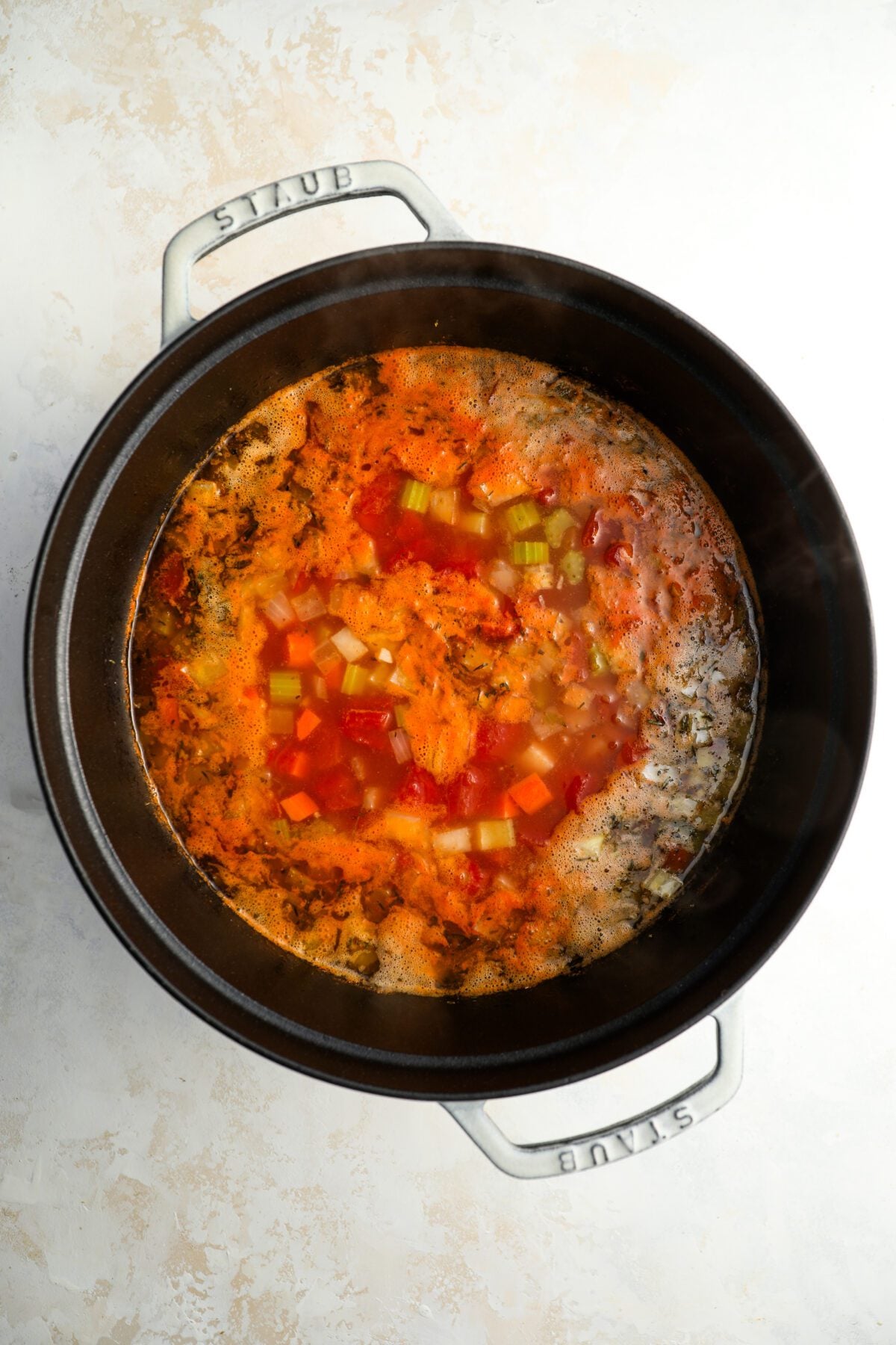 Dutch oven with hicken stock, then add the tomatoes, tomato paste, beans, potatoes, salt, sugar, thyme, oregano, and pepper added to garlic, onion, carrots and celery