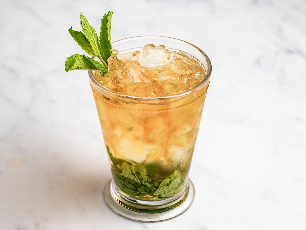 mint julep in tall glass with mint sprig garnish 