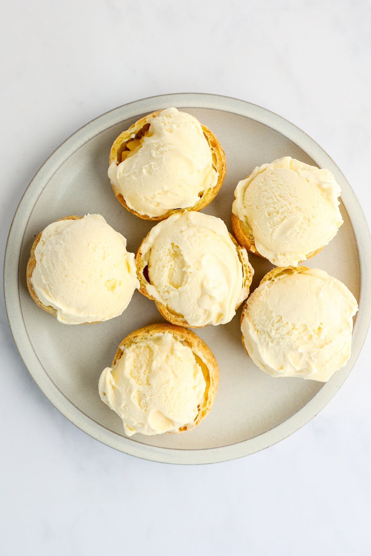 gray plate with 6 pastry shell bottoms topped with ice cream balls