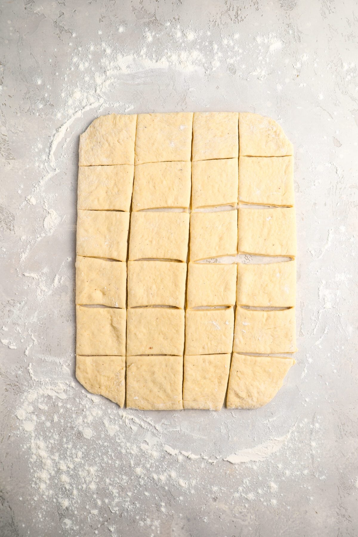 rolled and cut beignet dough on counter