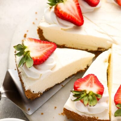 splatula lifitng one slice of strawberry topped no bake cheesecake