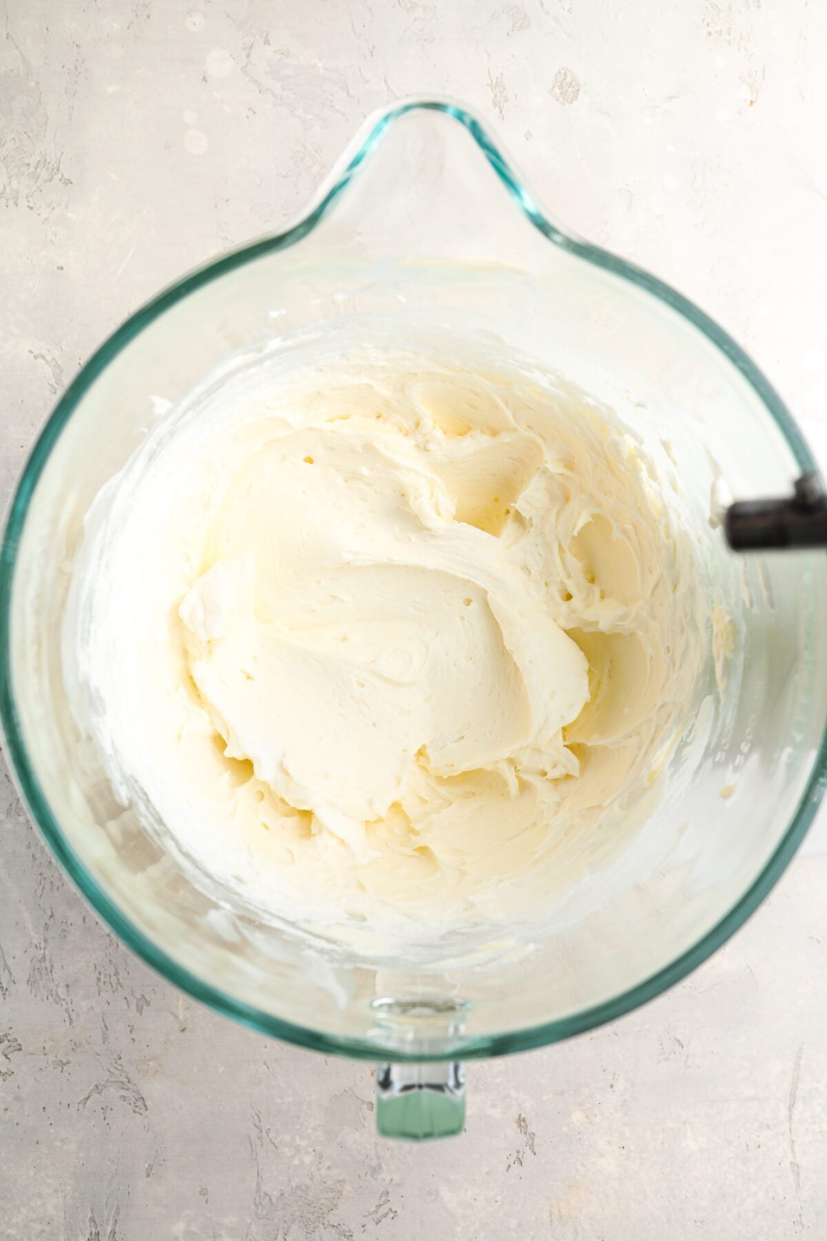 mixing bowl with smooth and creamycream cheese, sugar, lemon juice, vanilla, and salt mixture