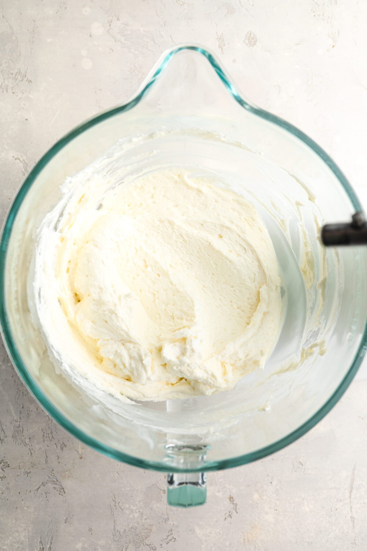 mixing bowl with portion of whipped cream whipped cream into cream cheese/sugar mixture