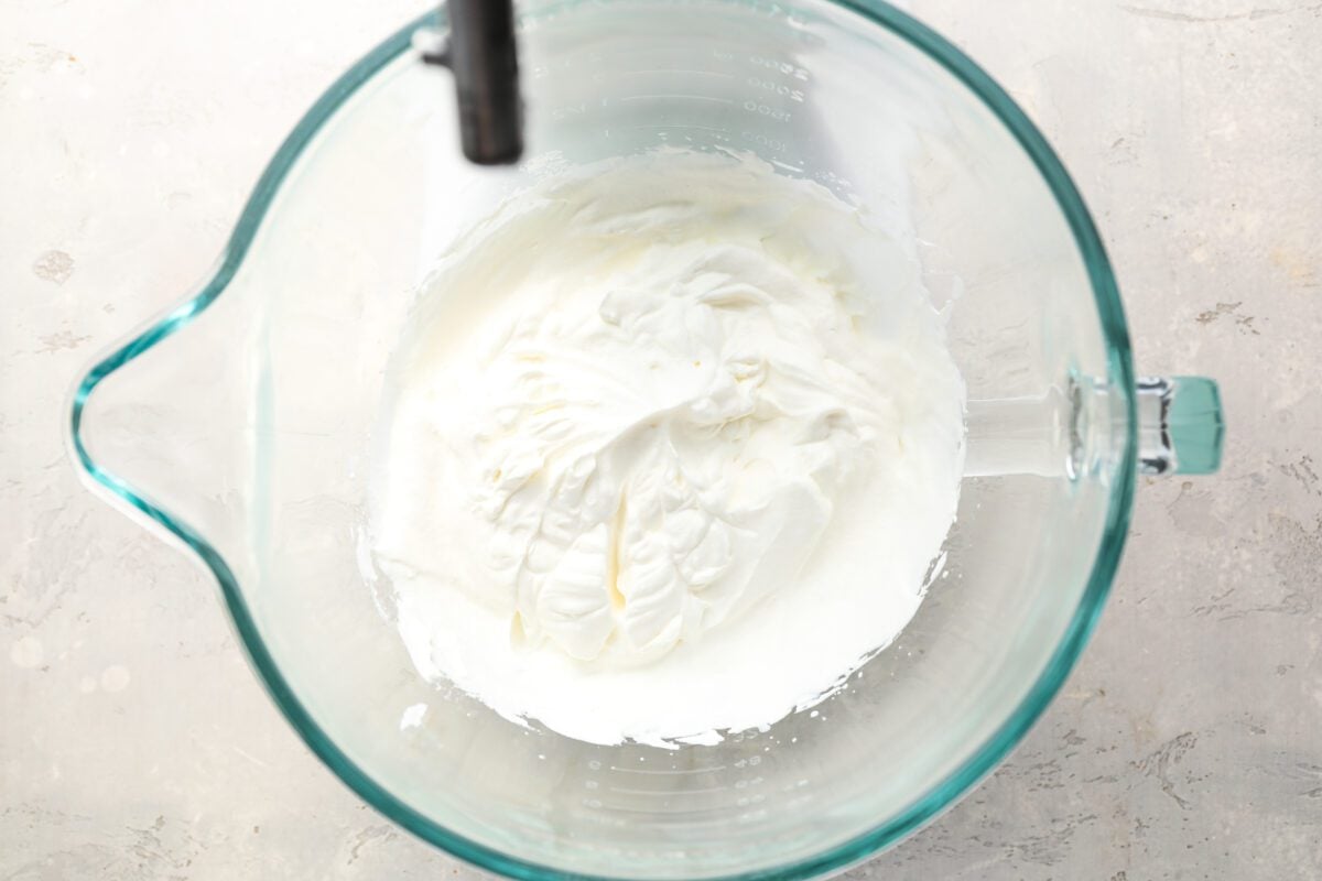 Heavy cream in glass mixing bowl whipped to medium stiff peaks