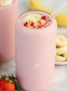 clear glass with strawberry banana topped with diced strawberry and banana