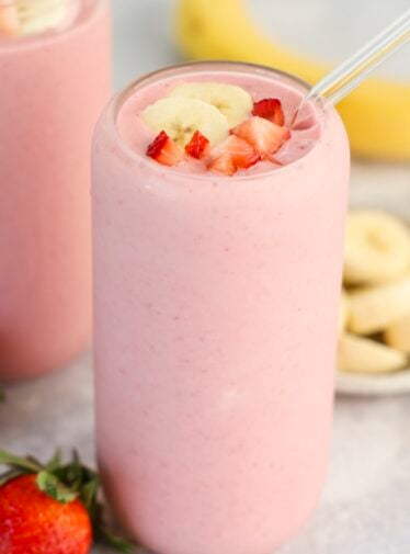 clear glass with strawberry banana topped with diced strawberry and banana