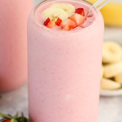 clear glass with strawberry banana topped with diced strawberry and banana