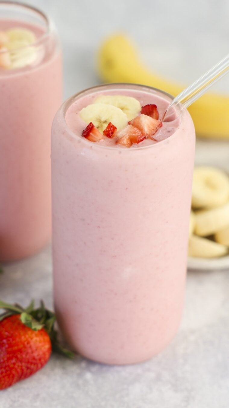 clear glass with strawberry banana topped with diced strawberry and banana