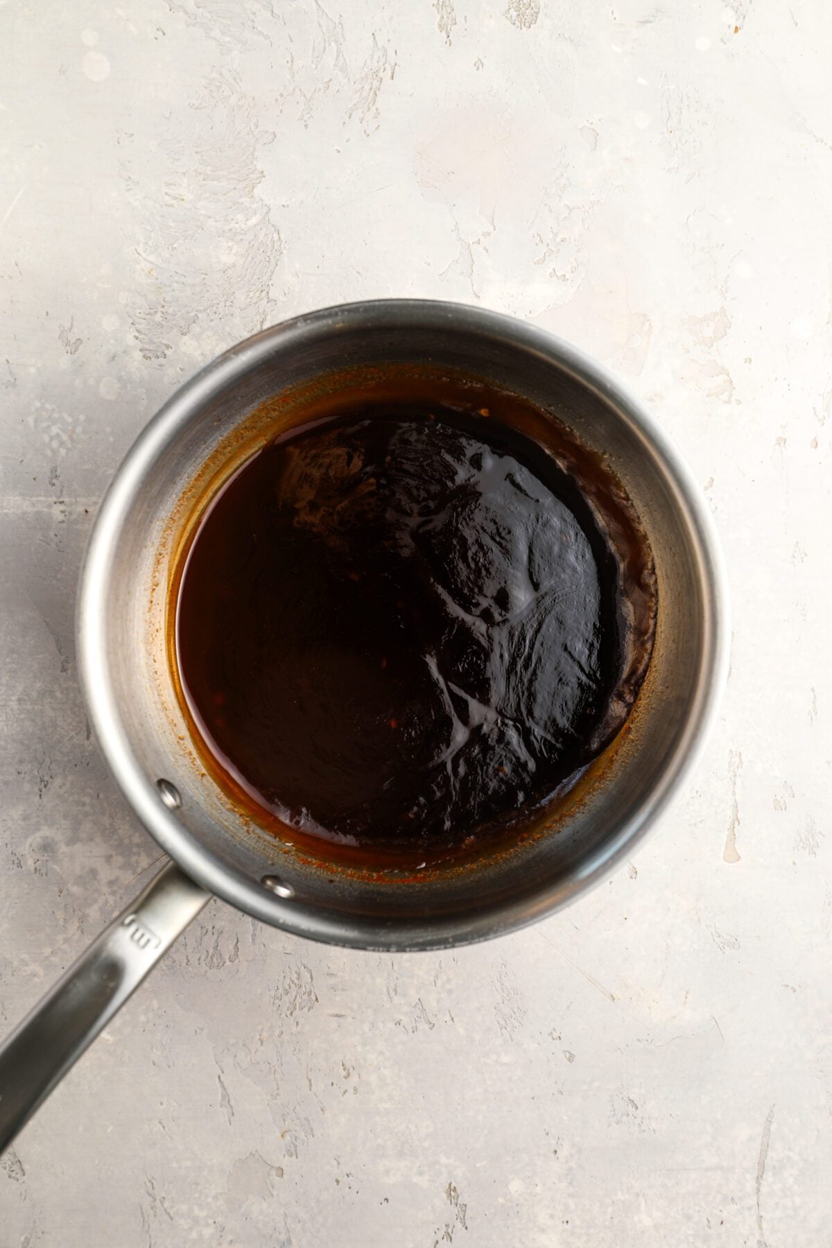 medium saucepan with sweet and sour sauce thickened with cornstarch slurry