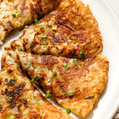 Sliced hash browns on white plate.