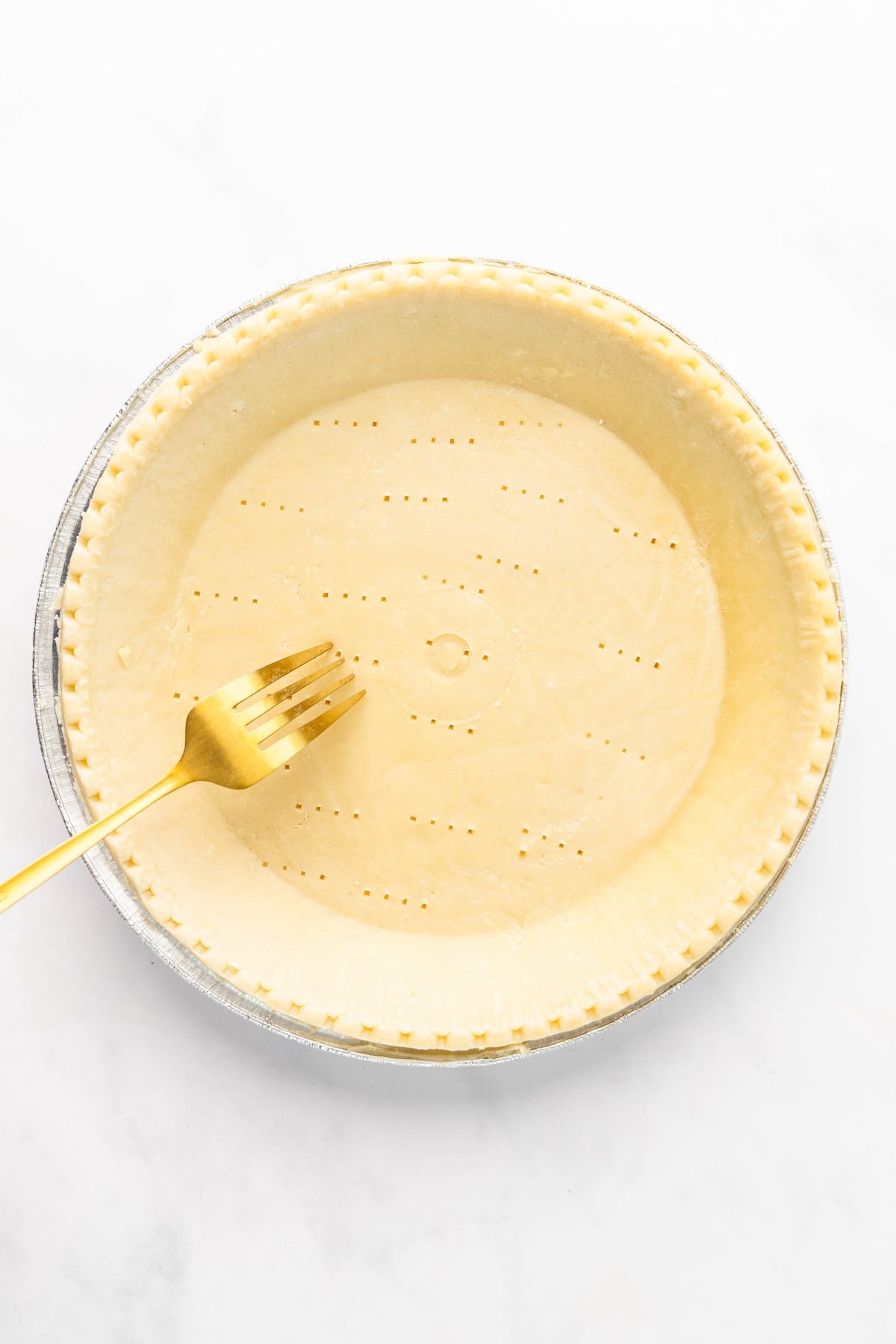 pricking unbaked pie crust with a fork