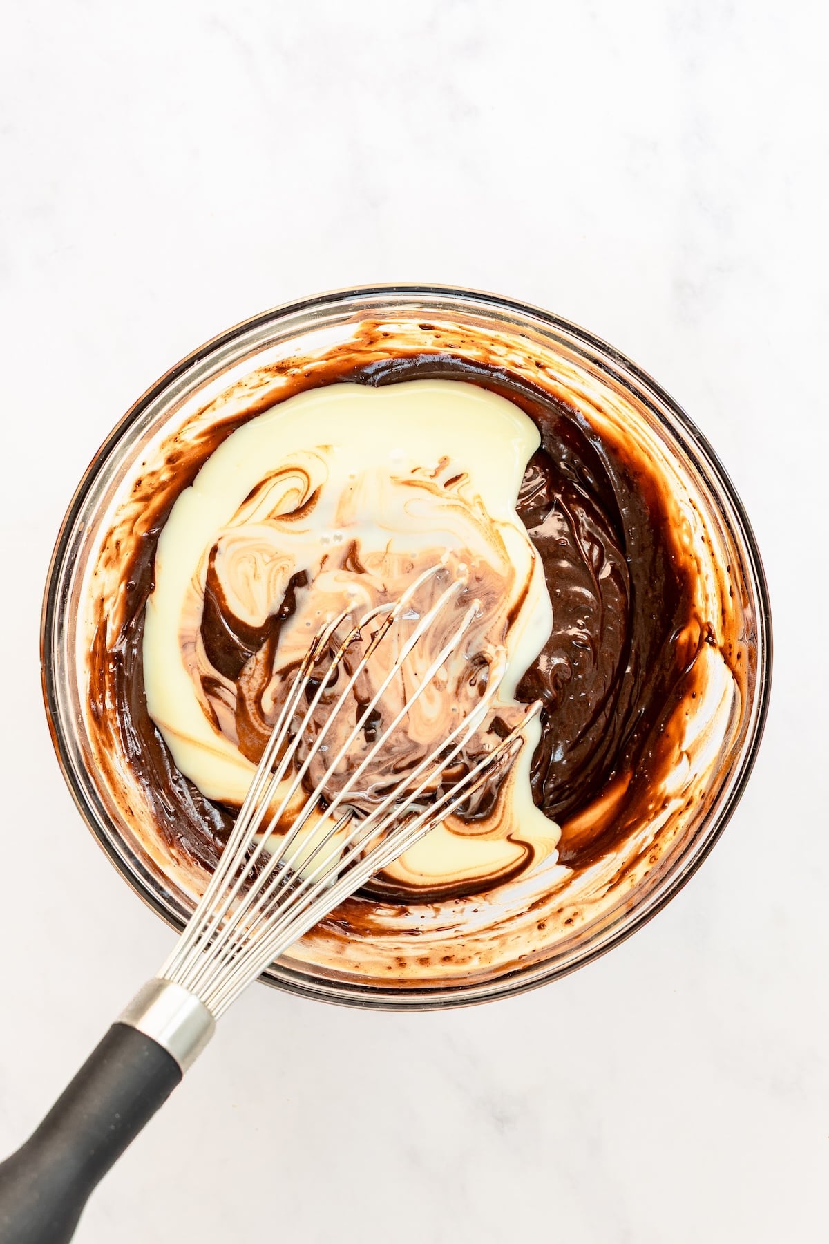 large bowl with sweetened condensed milk added to chocolate pudding