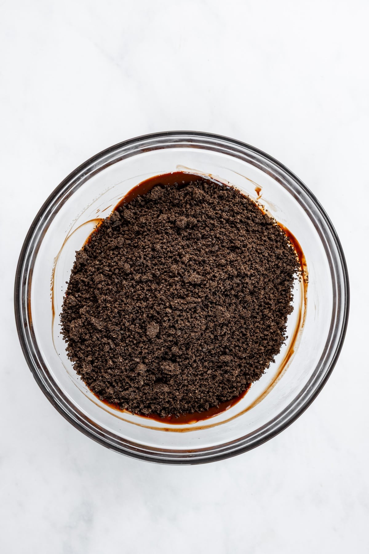 medium bowl with cookie crumbs on top of chocolate/butter mixture