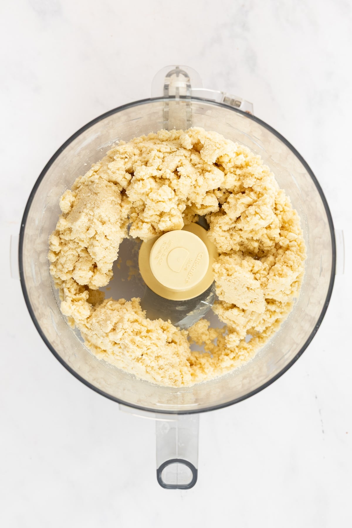 food processor with crust ingredients mixed to a crumbly consistency 