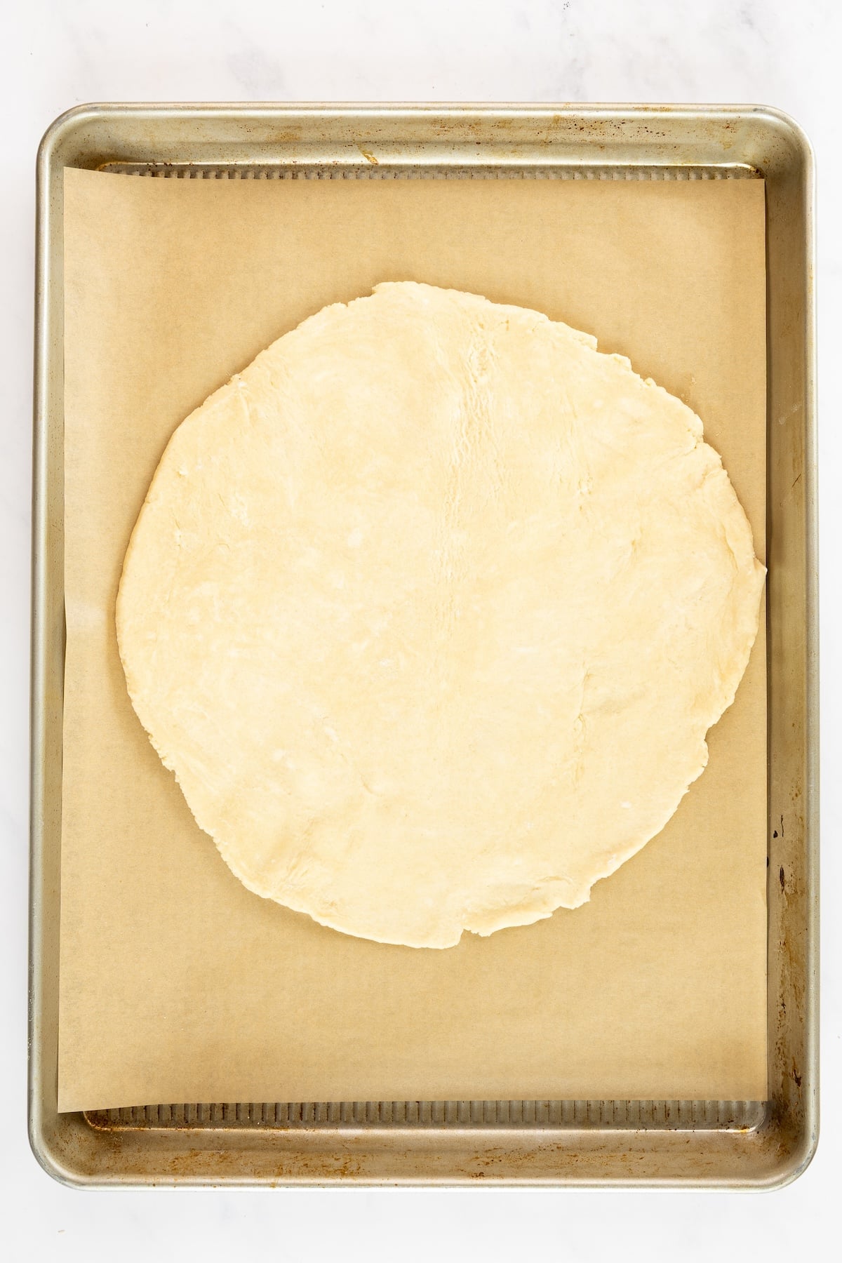 rolled galette crust on parchment lined baking sheet