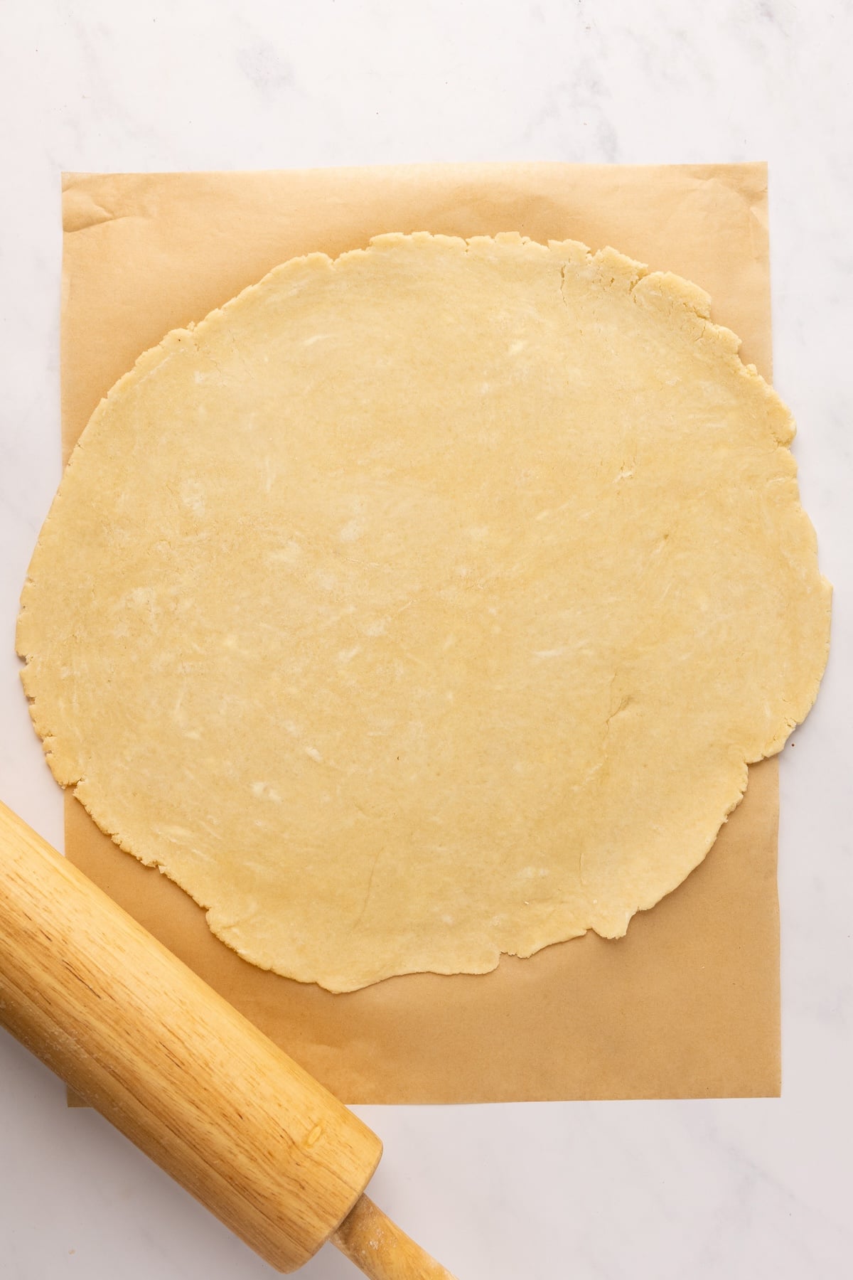 dough rolled into 13-inch circle on parchment on counter