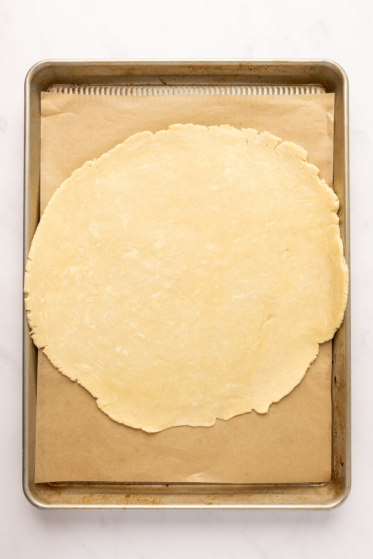 13-inch disk of dough on parchement lined baking sheet 