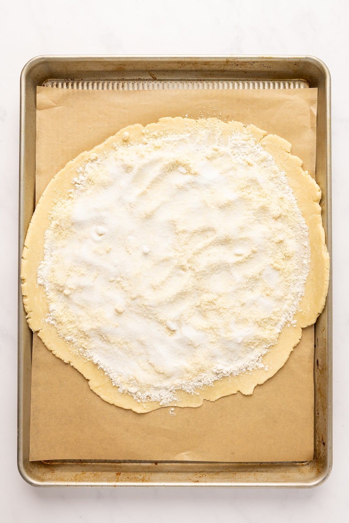 13-inch dough disk topped with layer of all purpose flour, almond flour, and granulated sugar