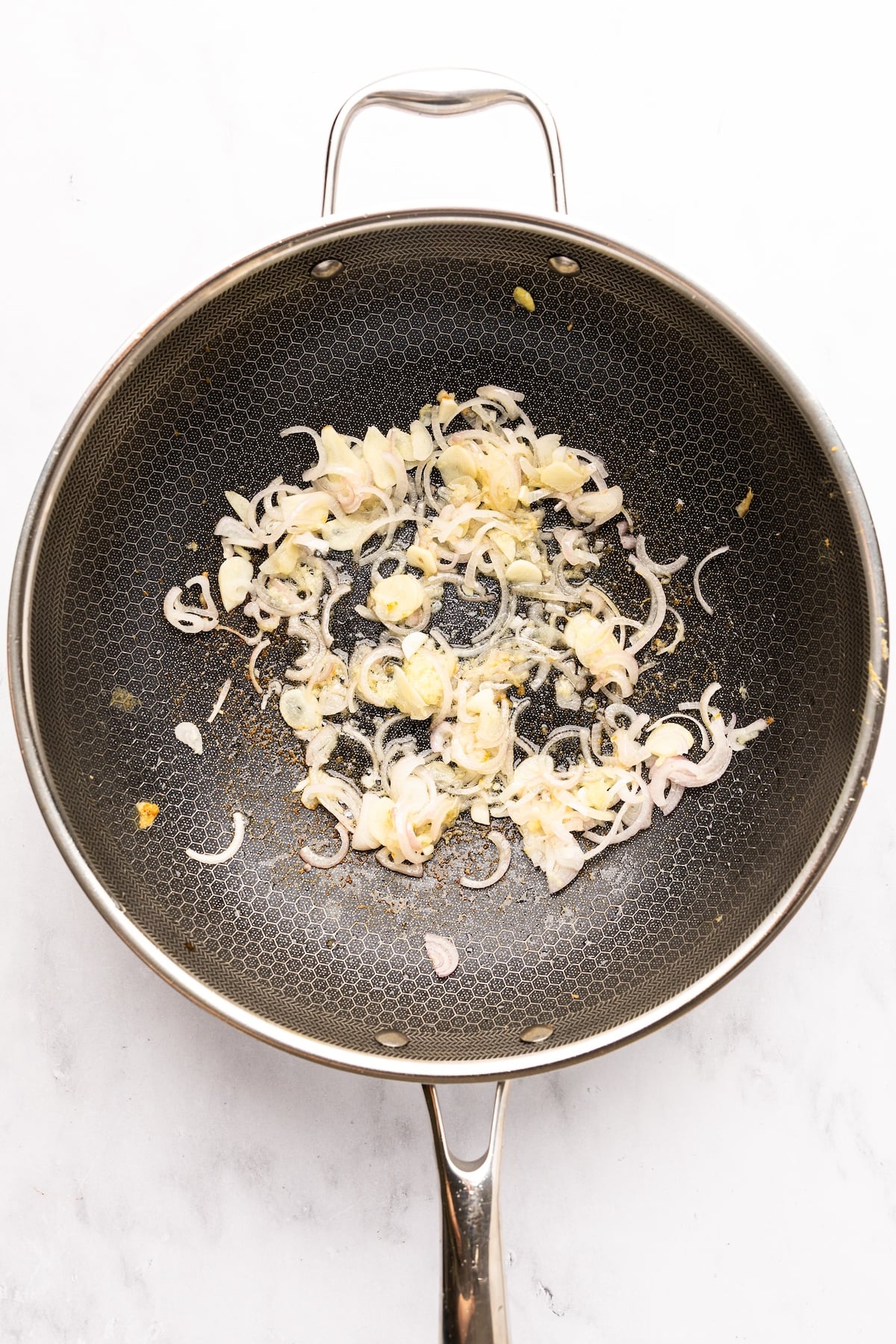 garlic, ginger, and shallots cooking in nonstick skillet