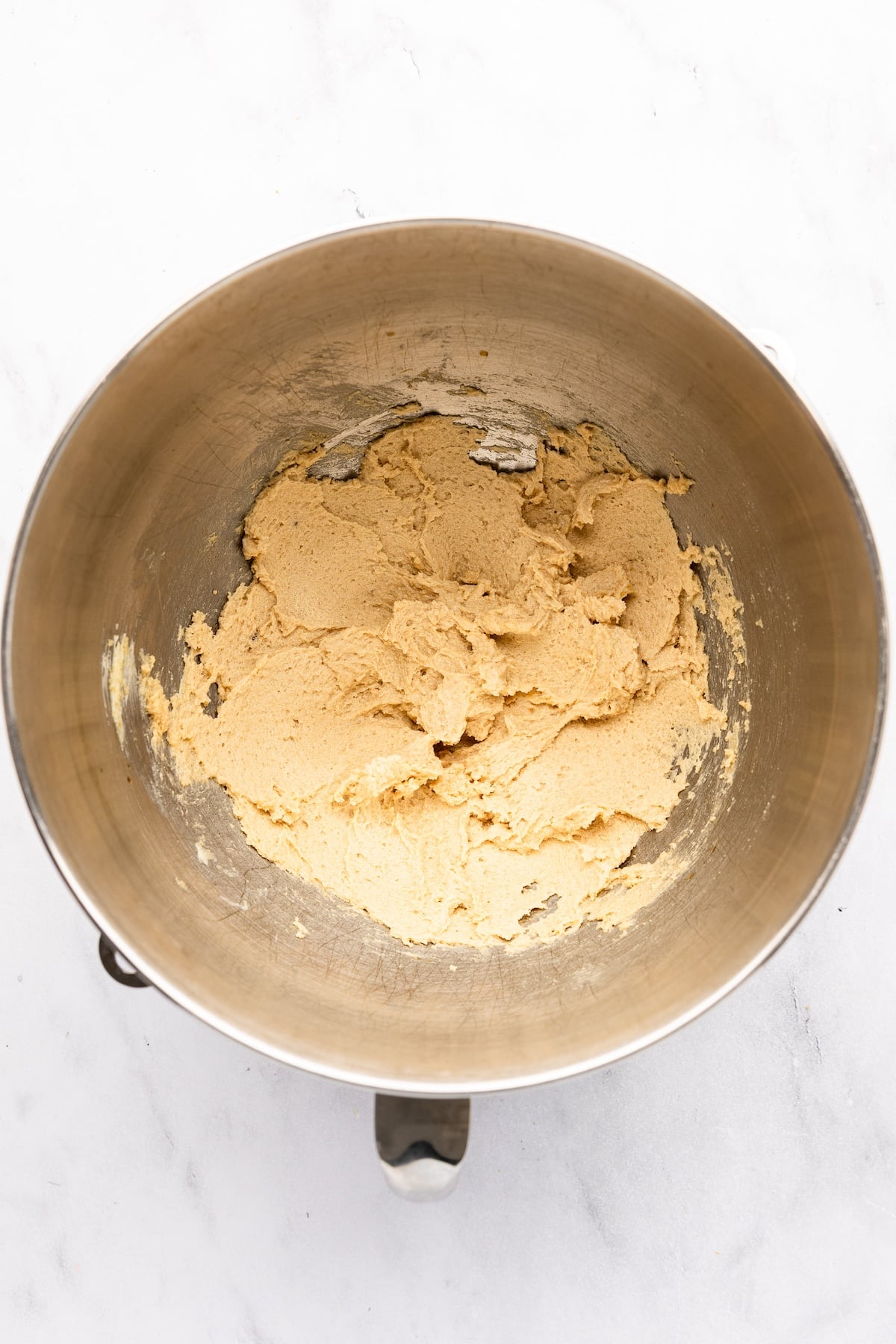 mixing bowl with butter, brown sugars, granulated sugar, vanilla, salt, baking powder, and baking soda combined