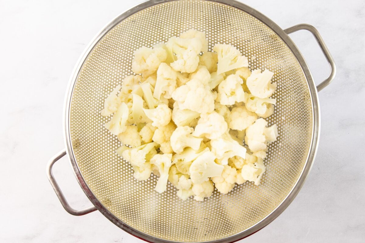 Par-boiled cauliflower in strainer.