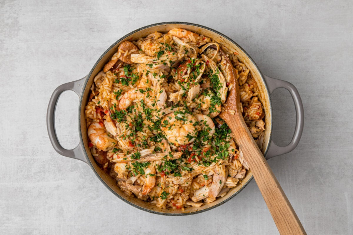 Finished jambalaya in Dutch oven with wooden spoon.