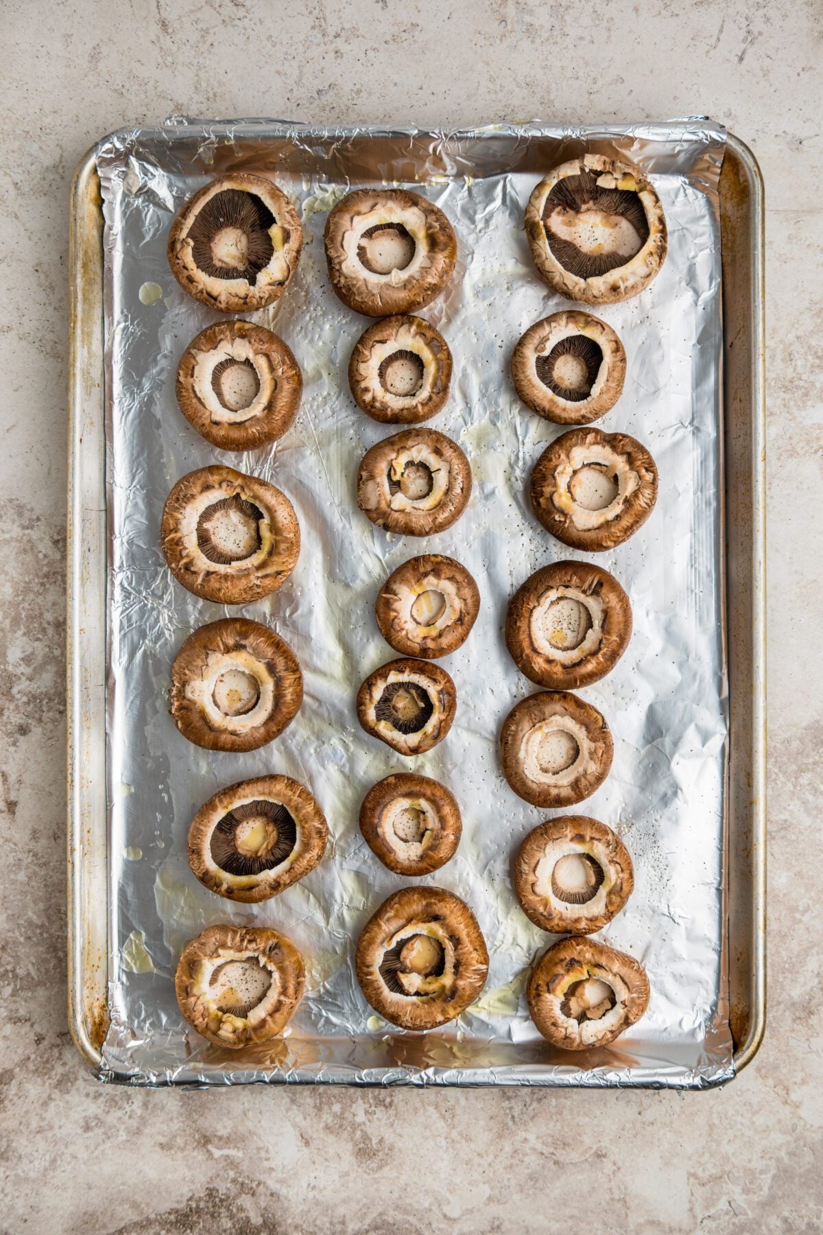 foil-lined baking sheet with mushroom caps evenly spaced face-up