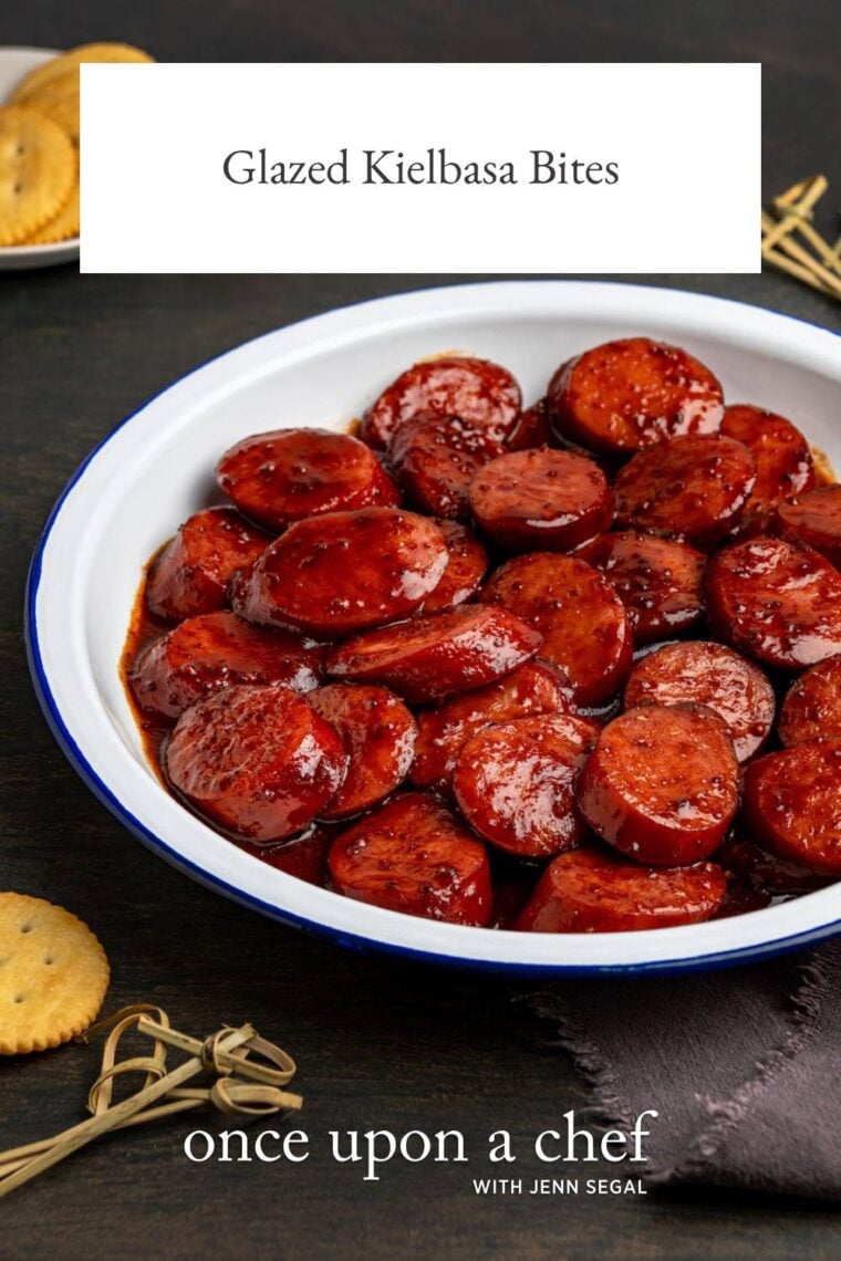 glazed kielbasa bites in a white bowl with toothpicks nearby